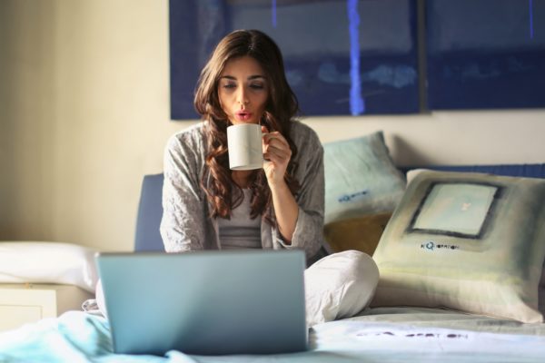 woman on laptop with hot drink
