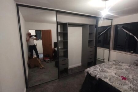 Mirrored wardrobe in white bedroom with middle open