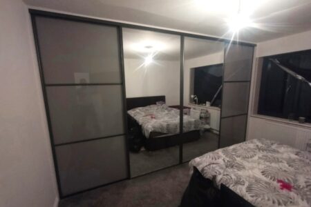 Mirrored wardrobe in white bedroom, closed